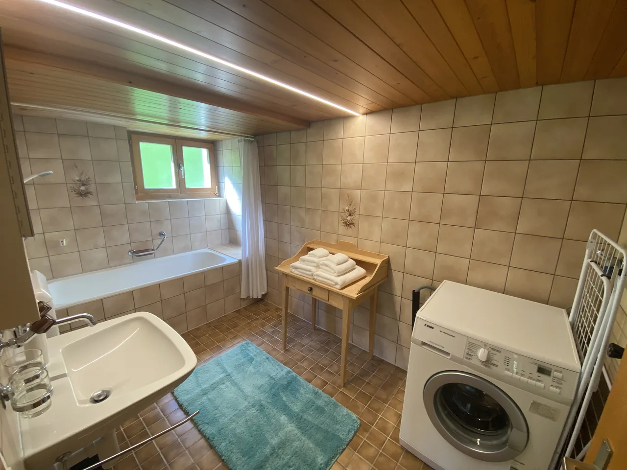Das Badezimmer mit Wanne und Waschmaschine