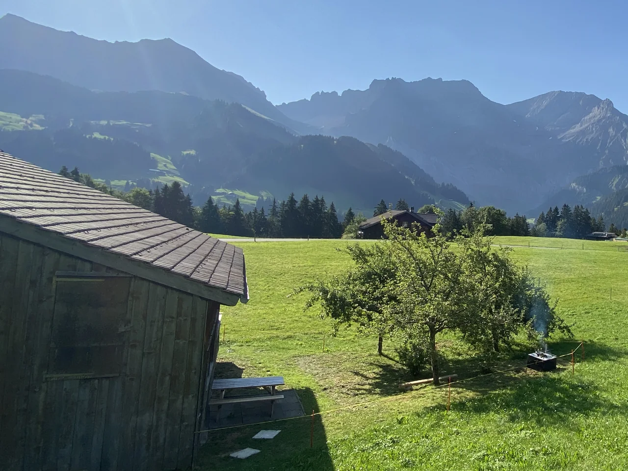 Die Terrasse mit dem Picknicktisch, dahinter die Wiese
